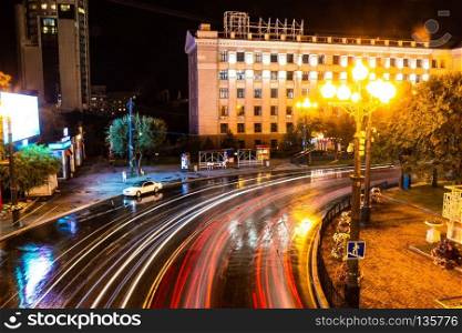 Night city landscape. The main square of the city of Khabarovsk in the light of lanterns, which are reflected in puddles after the rain just passed.. Khabarovsk, Russia - August 13, 2018: Lenin square at night under the light of lanterns.