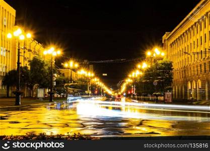Night city landscape. The main square of the city of Khabarovsk in the light of lanterns, which are reflected in puddles after the rain just passed.. Khabarovsk, Russia - August 13, 2018: Lenin square at night under the light of lanterns.
