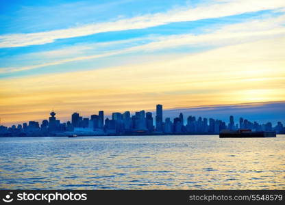 Night city, panoramic scene of downtown reflected in water. Sunset above Vancouver, Canada