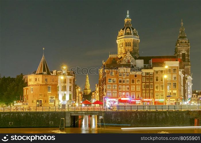 Night city view of Amsterdam canal and Basilica of Saint Nicholas, Holland, Netherlands.