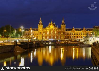 Night city view of Amsterdam canal and Centraal Station, Holland, Netherlands. Long exposure.