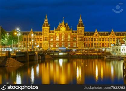 Night city view of Amsterdam canal and Centraal Station, Holland, Netherlands. Long exposure.