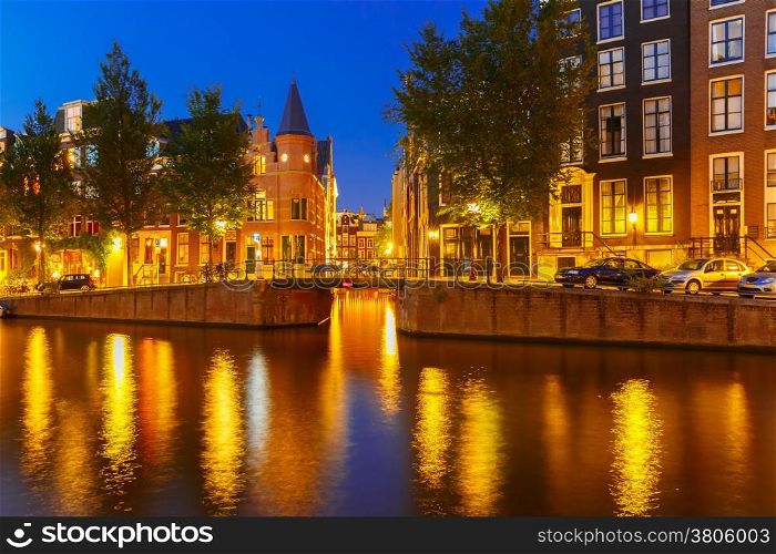 Night city view of Amsterdam canal, bridge and typical houses, Holland, Netherlands.
