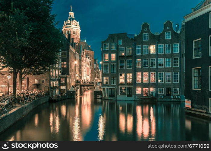 Night city view of Amsterdam canal, bridge and typical houses, Holland, Netherlands. Long exposure. Toning in cool tones