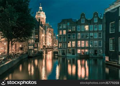Night city view of Amsterdam canal, bridge and typical houses, Holland, Netherlands. Long exposure. Toning in cool tones