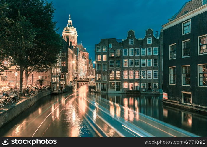 Night city view of Amsterdam canal, bridge and typical houses, Holland, Netherlands. Long exposure.. Toning in cool tones