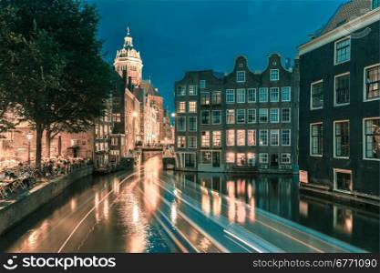 Night city view of Amsterdam canal, bridge and typical houses, Holland, Netherlands. Long exposure.. Toning in cool tones