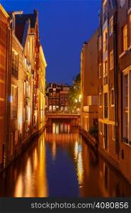 Night city view of Amsterdam canal, bridge, typical houses and bicycles, Holland, Netherlands.