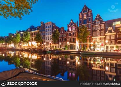 Night city view of Amsterdam canal Herengracht. Amsterdam canal Herengracht with typical dutch houses and their reflections during morning blue hour, Holland, Netherlands.