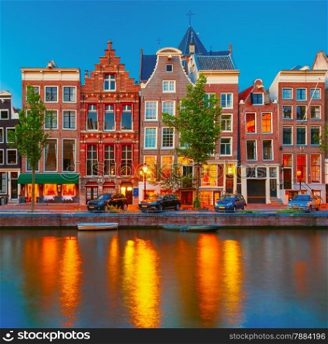 Night city view of Amsterdam canal Herengracht, typical dutch houses and boats, Holland, Netherlands.