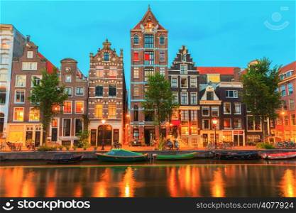 Night city view of Amsterdam canal Herengracht with typical dutch houses, boats and bicycles, Holland, Netherlands.