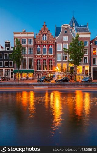 Night city view of Amsterdam canal, typical dutch houses and boats, Holland, Netherlands.