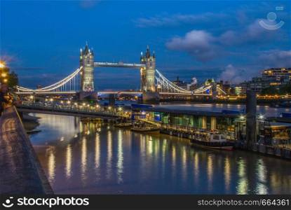 Night cityscape with Famous Tower Bridge in the evening with blue sky and reflex on water, London, England