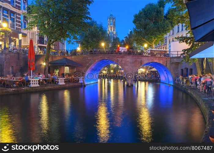 Night Dom Tower and bridge, Utrecht, Netherlands. Dom Tower and canal Oudegracht in the night colorful illuminations in the blue hour, Utrecht, Netherlands