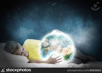 Night dreaming. Cute boy sitting in bed and dreaming. Elements of this image are furnished by NASA