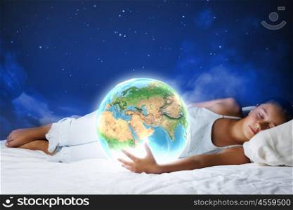 Night dreaming. Cute girl sleeping in bed and looking at Earth planet. Elements of this image are furnished by NASA