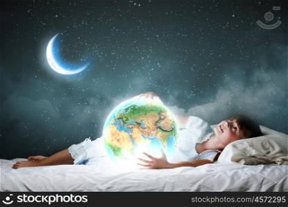 Night dreaming. Cute girl sleeping in bed and looking at Earth planet. Elements of this image are furnished by NASA