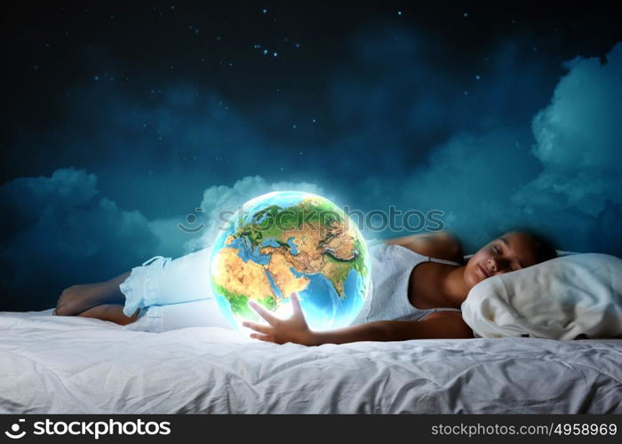 Night dreaming. Cute girl sleeping in bed and looking at Earth planet. Elements of this image are furnished by NASA