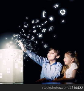 Night dreaming. Cute little boy and girl looking at model of house