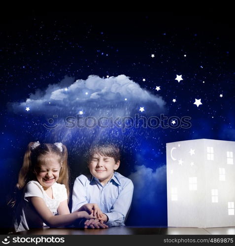 Night dreaming. Cute little boy and girl looking at model of house