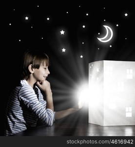 Night dreaming. Cute little boy in dark room dreaming about home and family