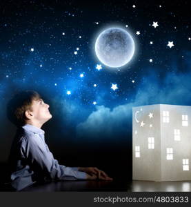 Night dreaming. Cute little boy in dark room dreaming about home and family