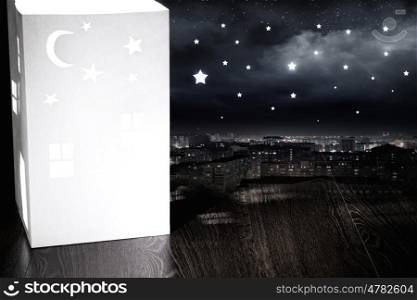 Night dreaming. Model of white paper house in darkness