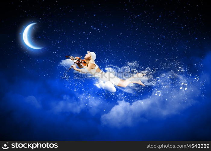 Night dreaming. Young blond girl flying in night sky