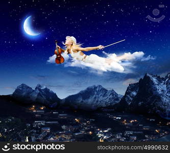 Night dreaming. Young blond girl flying in night sky