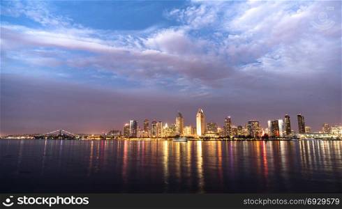 Night falls on San Diego California as the bay reflects lights from buildings downtown