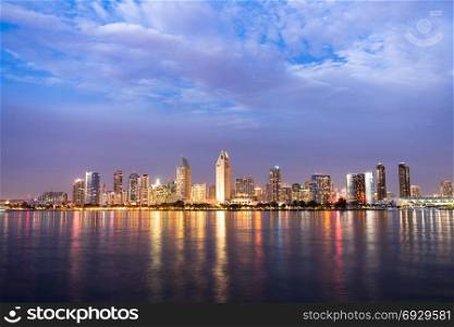 Night falls on San Diego California as the bay reflects lights from buildings downtown