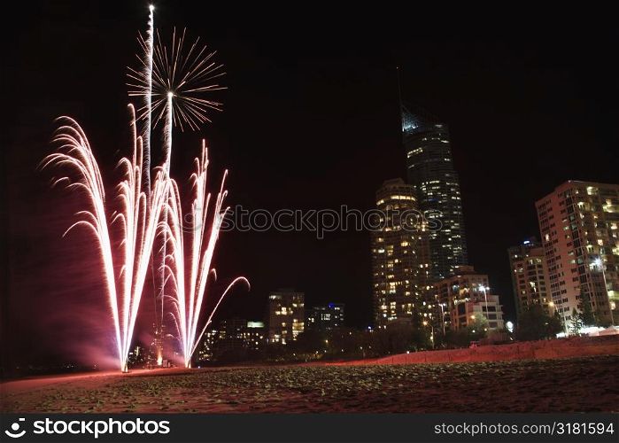 Night firework display exploding with Surfers Paradise city skyline in Australia.