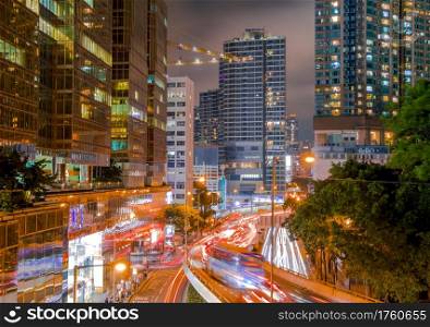 Night Hong Kong. Skyscrapers and green trees. Strong traffic. Night Street of Hong Kong with Skyscrapers and Traffic