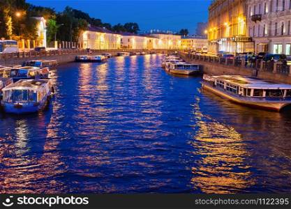 Night illuminated cityscape with boats at canal, Saint Petersburg, Russia