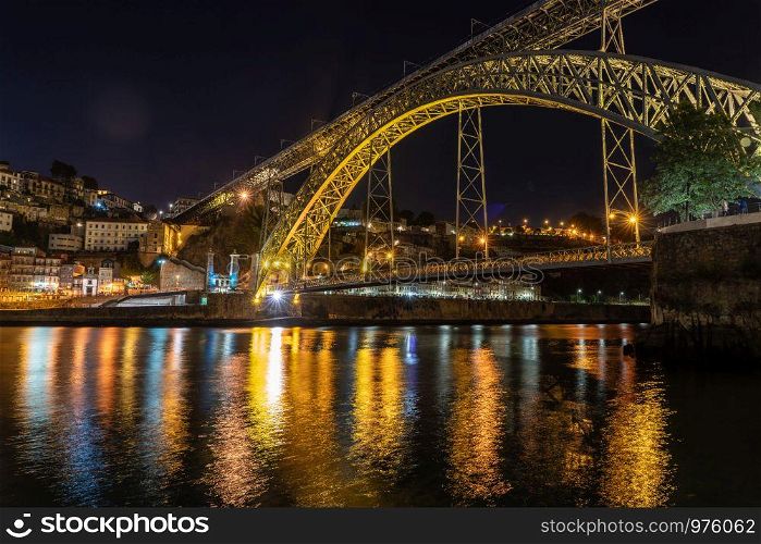Night illuminated metal arch bridge of Ponte Luis I from the banks of the river Douro. Night city skyline of Porto in Portugal with the Ponte Luis I bridge