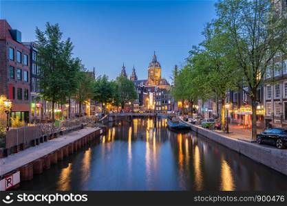 Night in Amsterdam city with Saint Nicholas Church at night in Amsterdam, Netherlands.