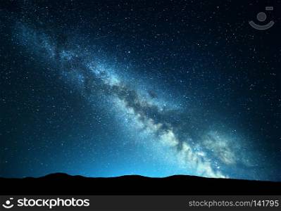 Night landscape with amazing Milky Way at mountains. Blue night starry sky with hills at summer. Beautiful Galaxy. Universe. Space background