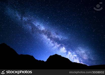 Night landscape with colorful Milky Way and blue light at mountains. Starry sky with rocks at summer. Beautiful Universe
