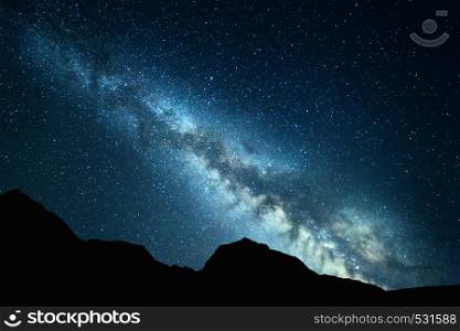 Night landscape with colorful Milky Way at mountains. Starry sky with rocks at summer. Beautiful Universe