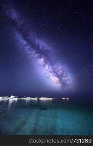 Night landscape with colorful Milky Way at the sea with stones. Starry sky. Space background
