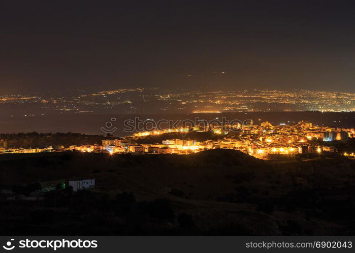 Night Lentini town view in direction from mountain road to sea and Etna volcano (Siracusa, Sicily, Italy)