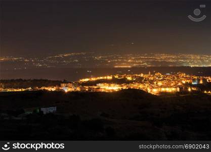 Night Lentini town view in direction from mountain road to sea and Etna volcano (Siracusa, Sicily, Italy)