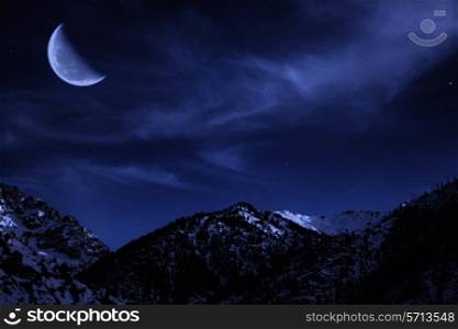 Night mountain winter landscape with the moon and stars in the sky