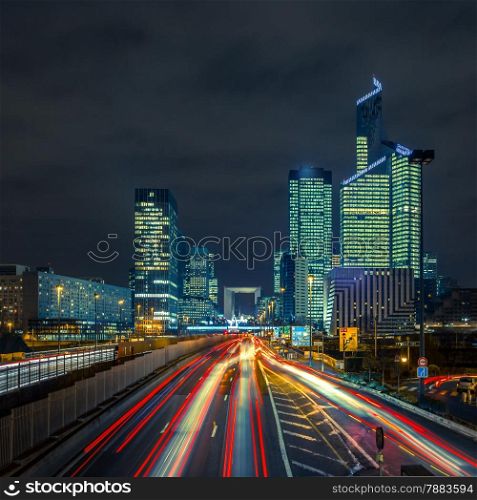 Night multi-lane road with skyscrapers of the La Defense, Paris, France. Long exposure.