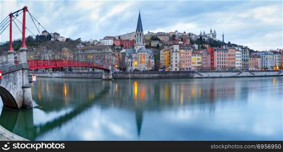 Night old town of Lyon, France. Panoramic view of Saint Georges church and footbridge across Saone river, Old town with Fourviere cathedral during evening blue hour in Lyon, France