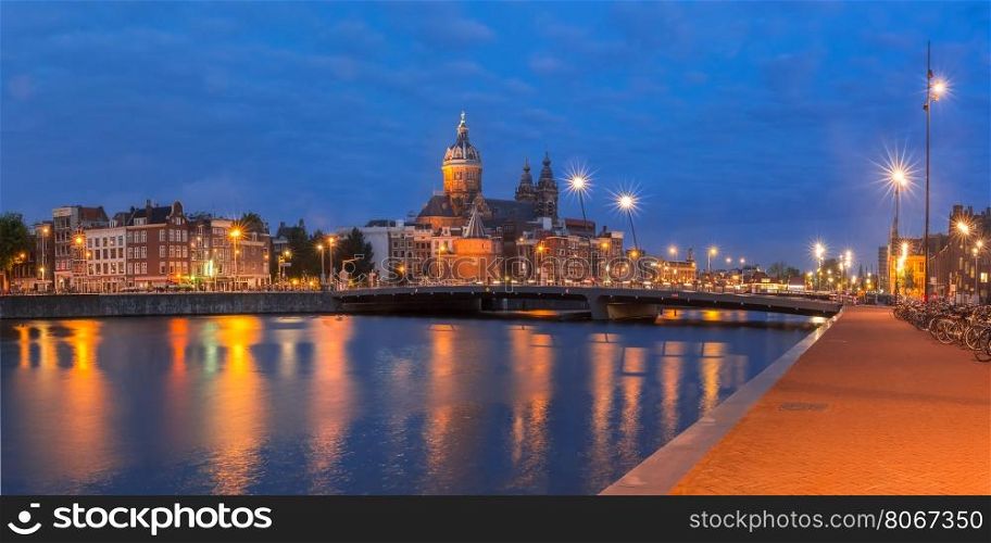 Night panoramic city view of Amsterdam canal, bridge and Basilica of Saint Nicholas, Holland, Netherlands. Long exposure.
