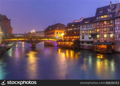Night Petite France in Strasbourg, Alsace. Traditional Alsatian half-timbered houses and bridge in Petite France during twilight blue hour, Strasbourg, Alsace, France
