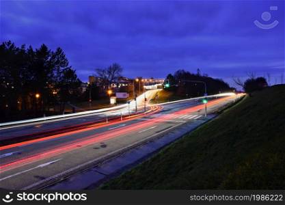 Night photo traffic on the road. Evening landscape with cars. Cars with lights and blurred color lines.