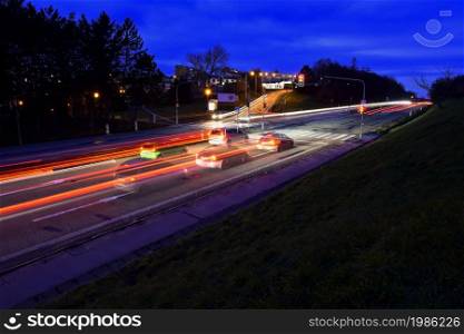 Night photo traffic on the road. Evening landscape with cars. Cars with lights and blurred color lines.