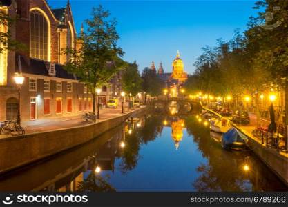 Night red-light district De Wallen, canal, bridge, Basilica of Saint Nicholas and its mirror reflection, Amsterdam, Holland, Netherlands. Long exposure.